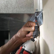 Person using a drill to install a metal panel on a wall.