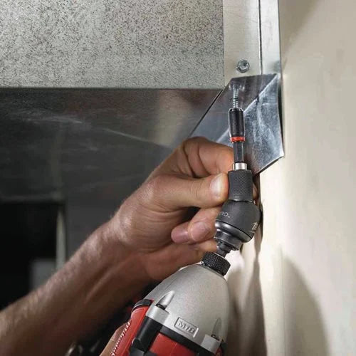 Person using a drill to install a metal panel on a wall.