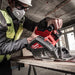 Person using a Milwaukee power tool in a construction setting