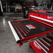 Red Milwaukee tool chest with open drawer in a workshop setting