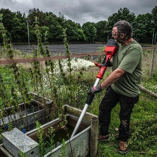 Person using M18 HYDROPASS brushless stick water pump