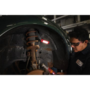 Mechanic using Milwaukee IR FFL internal rechargeable folding flood light in wheel well