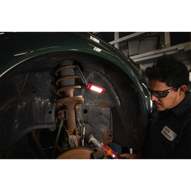 Mechanic using Milwaukee IR FFL internal rechargeable folding flood light in wheel well