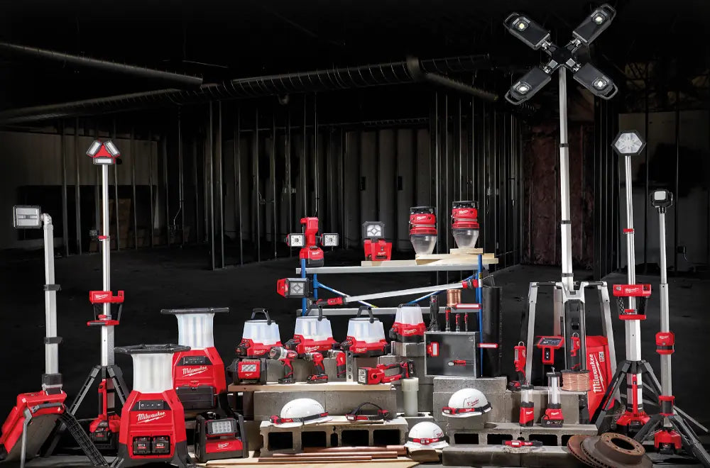 Collection of Milwaukee tools and equipment on display in a dark room.